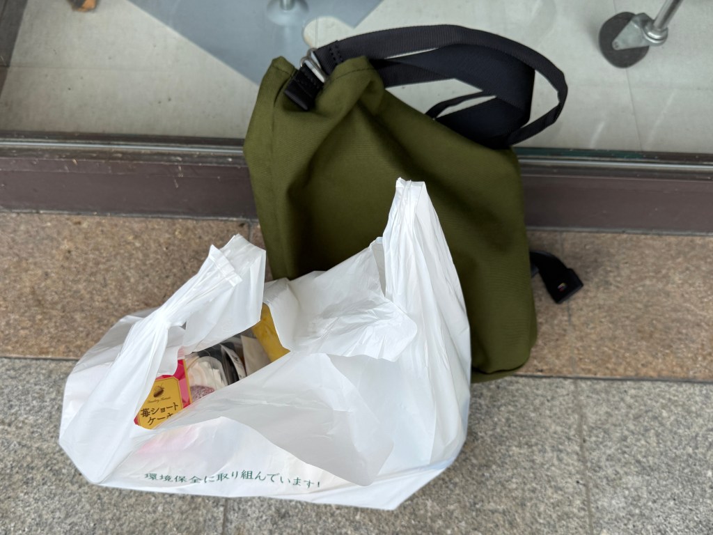 スーパーの出口に置かれた買い物バッグとレジ袋